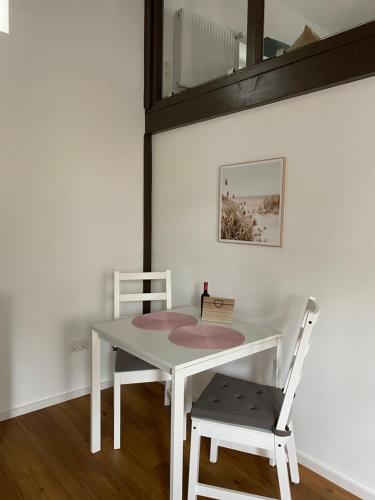 a white table with two chairs and a mirror at Scheunentraum Brenig in Bornheim