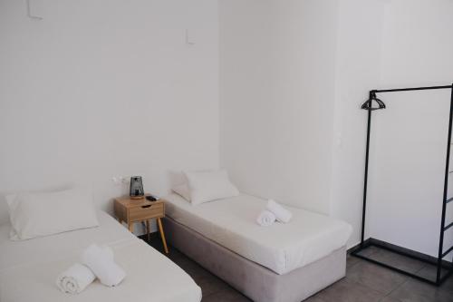 a white room with two beds and a lamp at Paradise Apartments Studios in Mylopotas