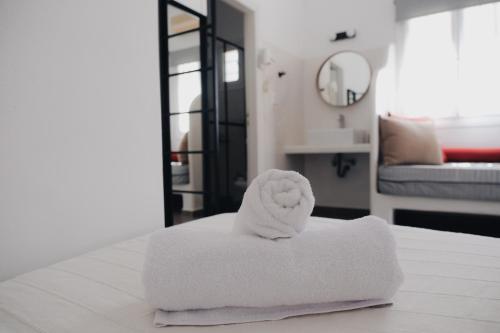 a pile of towels sitting on top of a bed at Paradise Apartments Studios in Mylopotas