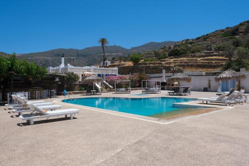 a swimming pool with lounge chairs and a resort at Paradise Apartments Studios in Mylopotas