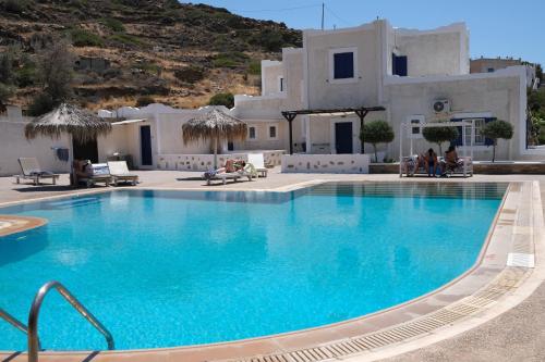 a swimming pool with blue water in front of a building at Paradise Apartments Studios in Mylopotas