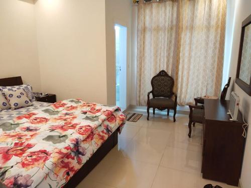a bedroom with a bed and a desk and a chair at Bhurban Continental Apartment 45-F in Bhurban