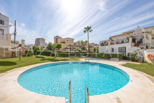 a large swimming pool in a yard with buildings at Bonito piso a 300m de la playa Nerja in Nerja