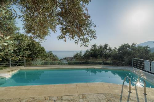 a swimming pool with a view of the ocean at Ouzo Panoramic Houses 2, with private pool in Plomarion