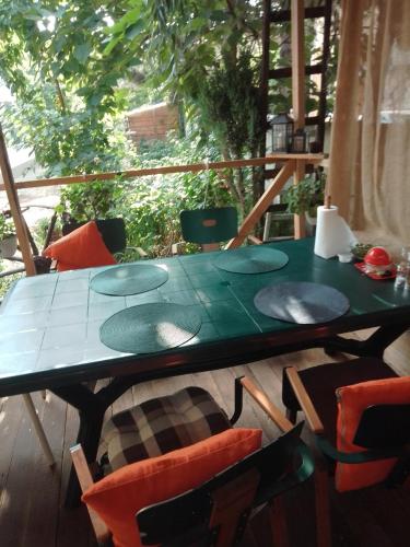 a green table and chairs on a deck with a table at Casa Mocanu in Giurgiu
