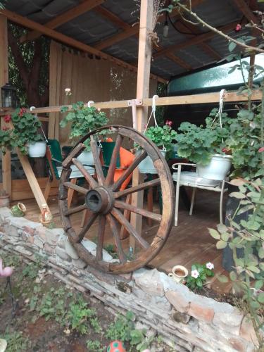 a wooden wagon wheel sitting next to some plants at Casa Mocanu in Giurgiu