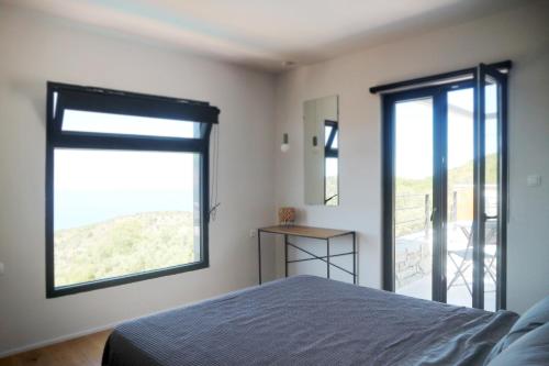a bedroom with a bed and a large window at Heterotopia Villas in Chortáta