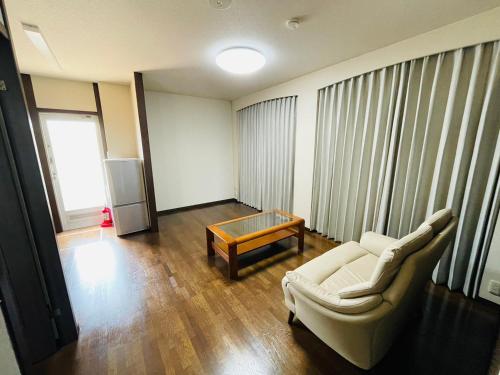 een woonkamer met een bank en een salontafel bij Prime 糸島 in Itoshima