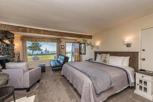 a bedroom with a bed and a couch and a chair at Juan de Fuca Cottages in Sequim