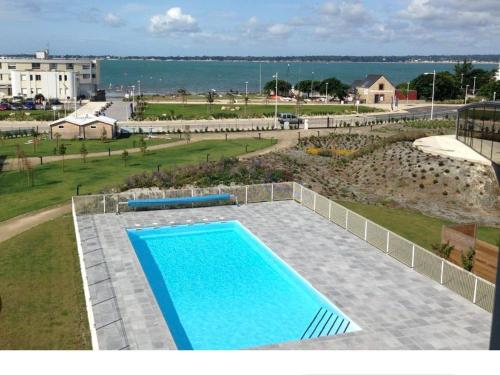 - une vue sur la piscine et l'océan dans l'établissement Les Thermes 532 - Vue mer avec piscine partagée, à Concarneau