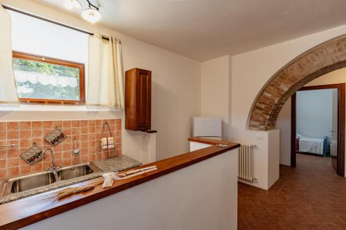 eine Küche mit einem Waschbecken und einem Fenster in der Unterkunft Masseria Del Bosco - Podere Palazzone in Chianciano Terme