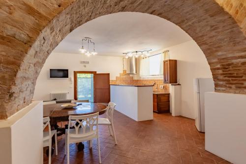 eine Küche und ein Esszimmer mit einem Tisch und Stühlen in der Unterkunft Masseria Del Bosco - Podere Palazzone in Chianciano Terme