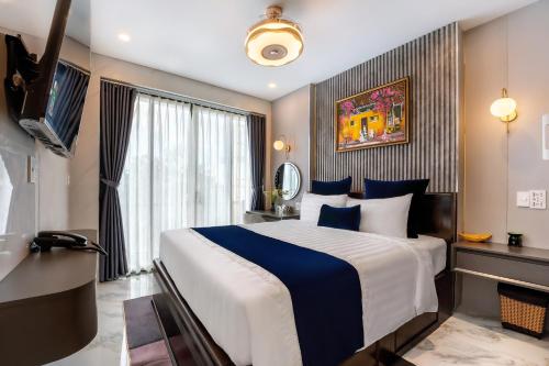 a hotel room with a large bed and a television at Hannah House Hoi An in Hoi An