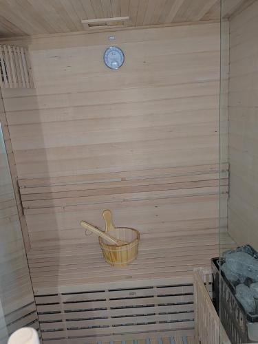 a clock on a wall with a basket on it at Hedonic Wellness Apartmani in Niš