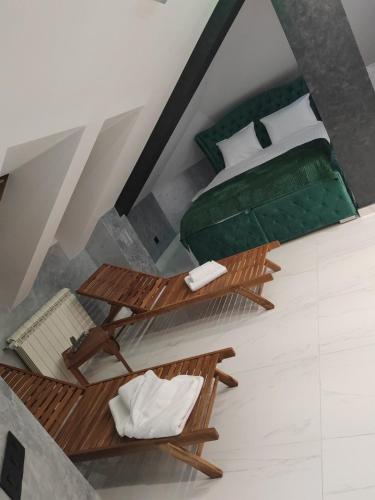 a bedroom with two tables and a green bed at Hedonic Wellness Apartmani in Niš
