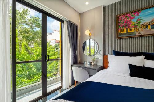 a bedroom with a bed and a large window at Hannah House Hoi An in Hoi An