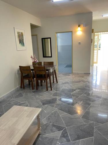 a dining room with a table and chairs on a tile floor at SEA LA VIE SWEET @ NAUTICA RESORT in Port Dickson