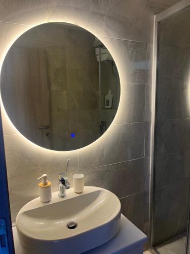 a bathroom with a white sink and a mirror at Square Vanilla Boutique Apart-Hotel in Skopje