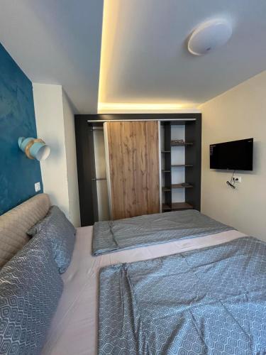 a small bedroom with a bed and a tv at Square Vanilla Boutique Apart-Hotel in Skopje