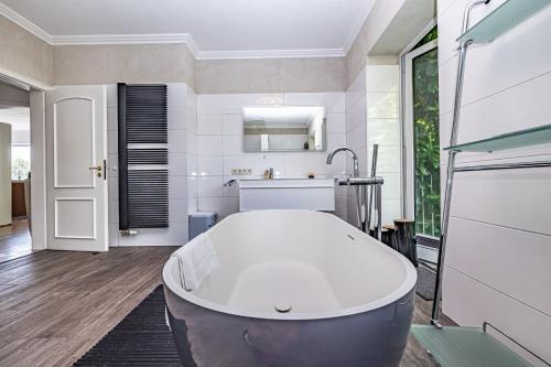 a large bathroom with a tub and a sink at Heimathafen Solitüde - Hafenmeister - elegante Wohnung mit 2 Schlafzimmern und Terrasse in Flensburg