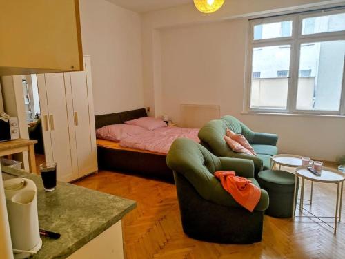 a living room with a bed and a couch and chairs at Cosy warm apartment in the heart of Prague. in Prague