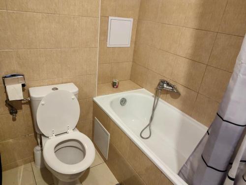uma casa de banho com um WC e uma banheira em Cosy warm apartment in the heart of Prague. em Praga