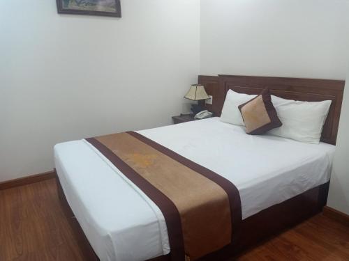 a bedroom with a large bed with white sheets at Khách Sạn Sông Hiến in Cao Bằng