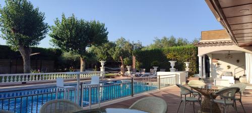 eine Terrasse mit Tischen und Stühlen neben einem Pool in der Unterkunft Hotel & Restaurant Figueres Parc in Figueres