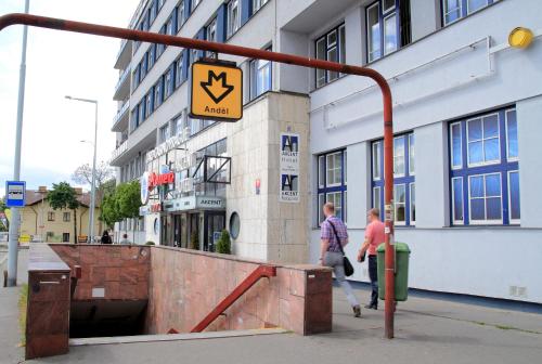 two people walking down a sidewalk in front of a building at Akcent hotel in Prague