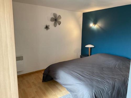 にあるAppartement indépendantの青い壁のベッドルーム1室(ベッド1台付)