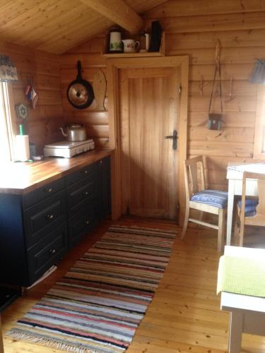 una cocina en una cabaña de madera con mesa y sillas en Mountain cabin Skoldungbu, en Vang I Valdres