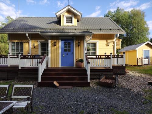 a small yellow house with a blue door at Villa Koskikorento in Kannus