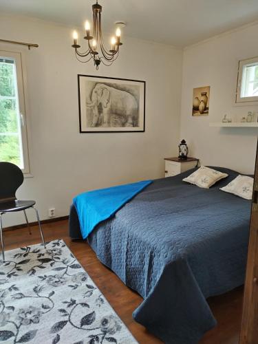 a bedroom with a blue bed and a chandelier at Villa Koskikorento in Kannus