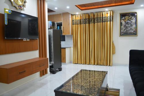 a living room with a flat screen tv and a couch at Luxury Apartment in Bahria Town, Lahore in Lahore