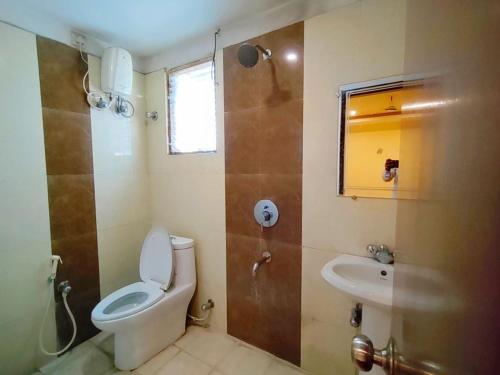 a bathroom with a toilet and a sink and a shower at Hotel Jasmin Palace in Angul
