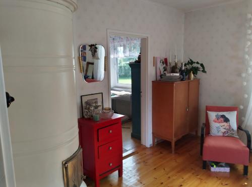 a living room with a red dresser and a mirror at Vintage 50's in Lahti