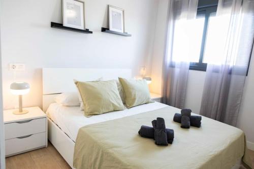 ein Schlafzimmer mit 2 Betten und schwarzen Handtüchern darauf in der Unterkunft Modern apartment, Pool & Air con, San Juan Playa in Alicante