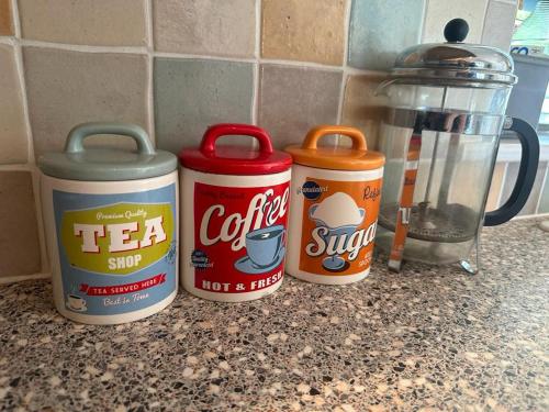 three cans of tea sitting on top of a counter at The Annex, Westerlands, Graffham in Graffham
