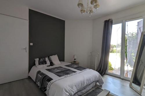 1 dormitorio con cama y ventana grande en RavissantT2 indépendant 4 p/ 3 lits park et patio, en Saint-Sever