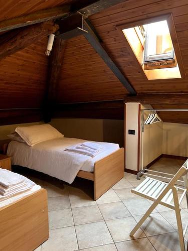 a attic bedroom with a bed and a window at Casa Victoria - Bellagio in Bellagio