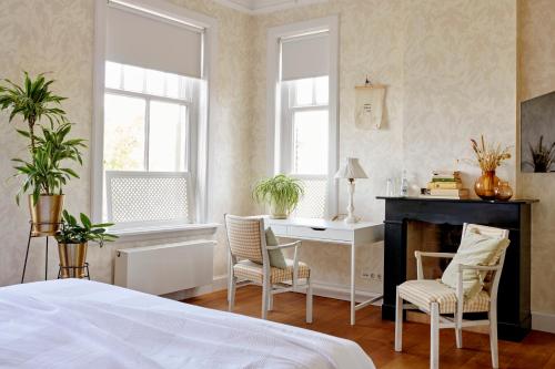 a bedroom with a bed and a desk and chairs at Hotel Station Amstelveen in Amstelveen