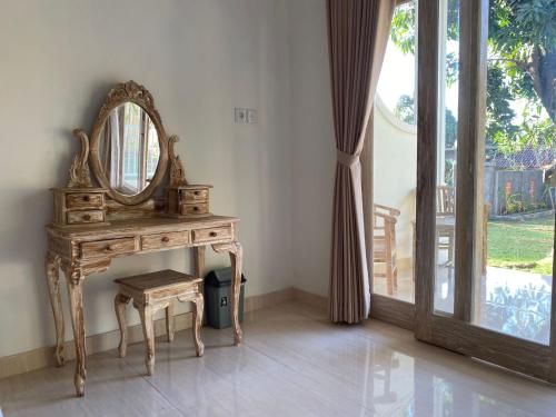 a dressing table with a mirror and a stool at Comeon Amed in Amed