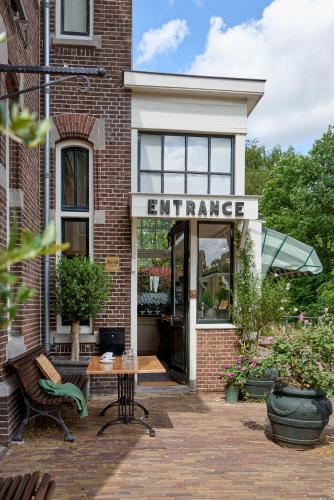 an entrance to a brick building with a sign that reads entrance at Hotel Station Amstelveen in Amstelveen