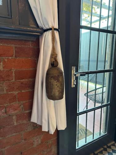 a door with a bell hanging next to a window at The Old Chocolate Shop in Canowindra
