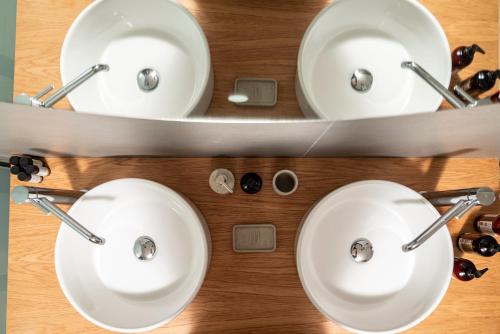 two white sinks in a bathroom with a mirror at RASTONI VILLAS BY AEGEAN HOUSES in Psalidi