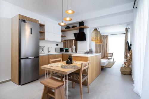 a kitchen with a table and a refrigerator at RASTONI VILLAS BY AEGEAN HOUSES in Psalidi