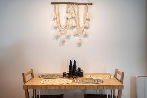 a dining room table with two chairs and a chandelier at RASTONI VILLAS BY AEGEAN HOUSES in Psalidi