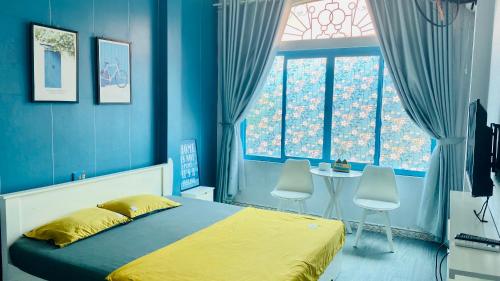 a blue bedroom with a bed and a table and chairs at La Casa Homestay - 11B Anh Đào, Bãi Cháy in Ha Long
