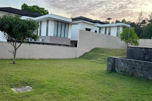 une maison avec une cour herbeuse devant elle dans l'établissement 4BR Private Villa with Pool in the Heart of city, à Batu Ampar