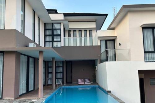 a house with a swimming pool in front of it at 4BR Private Villa with Pool in the Heart of city in Batu Ampar